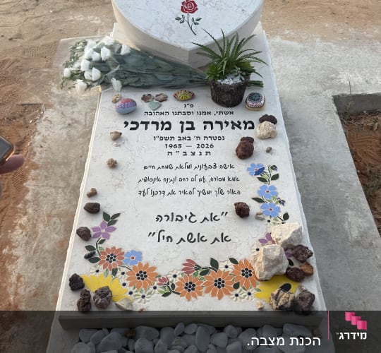 מצבה מעוצבת עם פרחים ואבנים צבעוניות